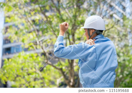 Man in work clothes stretching shoulders 115195688