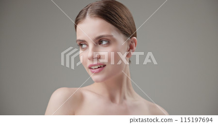 Beauty, health, cosmetics, anti-aging therapy and skin care concept - young beautiful brunette Caucasian woman posing and looking at the camera with a calm confident look like in a mirror 115197694