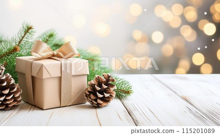 Christmas tree, gift and cones on a white wooden table. Space for text 115201089