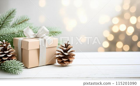 Christmas tree, gift and cones on a white wooden table. Space for text Christmas tree, gift and cones on a white wooden table. Space for text 115201090