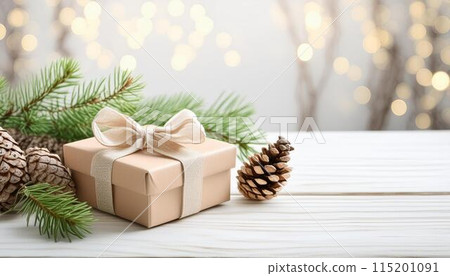 Christmas tree, gift and cones on a white wooden table. Space for text 115201091
