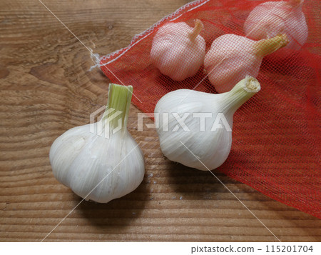 自然農業家庭花園收穫的大蒜存放在蔬菜網中的照片 115201704