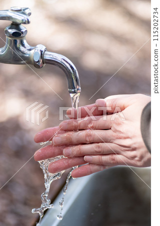 People washing their hands outdoors People washing their hands outdoors 115202734