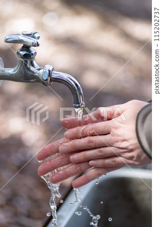 People washing their hands outdoors People washing their hands outdoors 115202737