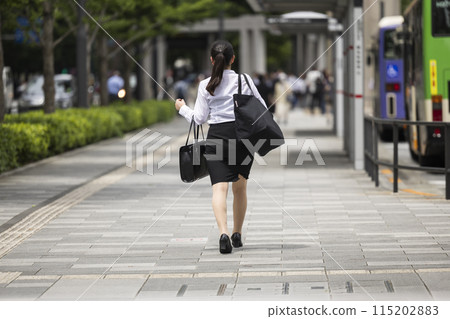 Young woman walking through Tokyo's business district Young woman walking through Tokyo's business district 115202883