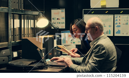 Investigators studying historical maps of crime scenes using federal classified records, officers reconstruct timelines using archived folders. Detectives conducting private investigation. Camera A. 115204139