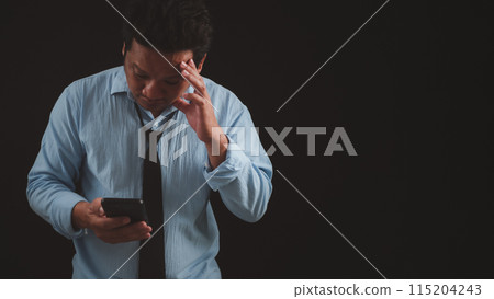 Man in a blue suit expresses disappointment or confusion while looking at his smartphone, a contrast to the positive interactions typically associated with professional communication. Man in a blue suit expresses disappointment or confusion while looking at his smartphone, a contrast to the positive interactions typically associated with professional communication. 115204243