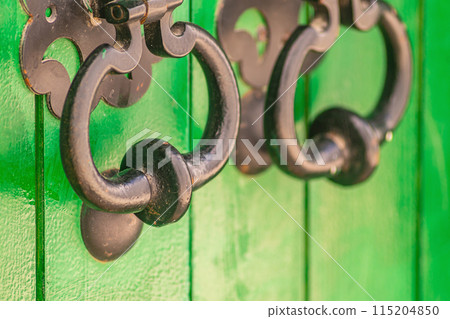 Metal door handles with large rings for knocking on the door, old methods of autonomous and eternal ringing of the doorbell to the owners of the house, knocker 115204850