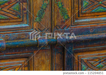 An antique rusty metal device for locking massive wooden gates. An object of antiquity and ancient cultural technology 115204851
