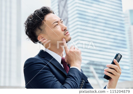 看智能手機並且認為的商人 115204879