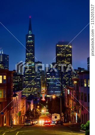 Cars driving up and down hill leading into downtown San Francisco skyscrapers on foggy night 115205327