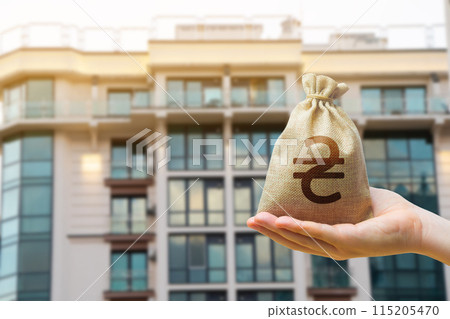 Ukrainian UAH bag against the background of modern high-rise buildings. Investing in the purchase of real estate. Affordable housing and mortgage rates. Renting apartments Ukrainian UAH bag against the background of modern high-rise buildings. Investing in the purchase of real estate. Affordable housing and mortgage rates. Renting apartments 115205470