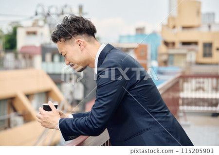 Businessman taking a break on the company balcony 115205901