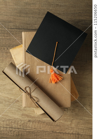 Graduate hat and books on wooden table Graduate hat and books on wooden table 115206650