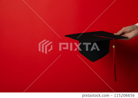 The hat of a university graduate, in his hands. 115206656