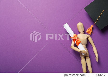 Wooden statuette of a man with a graduation hat and diploma. 115206657