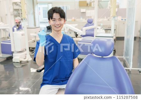 男性牙醫看著鏡頭時擺出拳頭 男性牙醫看著鏡頭時擺出拳頭 115207508