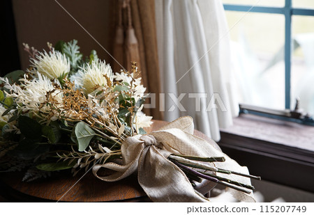 Bouquet of flowers on a table by the window 115207749