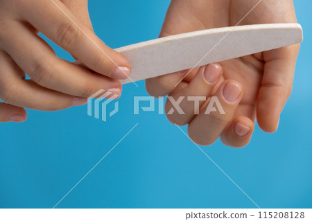 Pastel softness manicured nails on blue background. Woman showing her new manicure in colors of pastel palette. Simplicity decor fresh spring vibes earth-colored neutral tones Pastel softness manicured nails on blue background. Woman showing her new manicure in colors of pastel palette. Simplicity decor fresh spring vibes earth-colored neutral tones 115208128