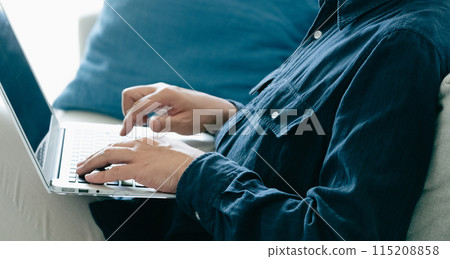 在沙發上使用電腦的男人 在沙發上使用電腦的男人 115208858