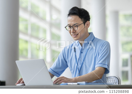 Image of a facility staff member working on a laptop 115208898
