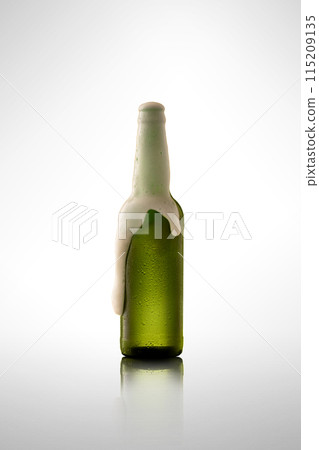 Party time. Green bottle overflowing with cold, refreshing, frothy craft beer against white studio background. Party time. Green bottle overflowing with cold, refreshing, frothy craft beer against white studio background. 115209135