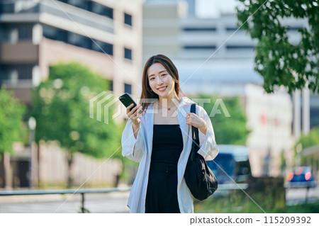 A young woman operating a smartphone A young woman operating a smartphone 115209392