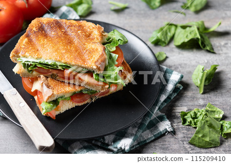 Healthy spinach, tomato and cheese sandwich on wooden table Healthy spinach, tomato and cheese sandwich on wooden table 115209410