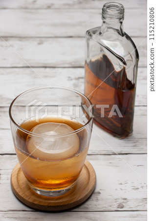岩石上的圓冰和一瓶垂直組合的威士忌 岩石上的圓冰和一瓶垂直組合的威士忌 115210806