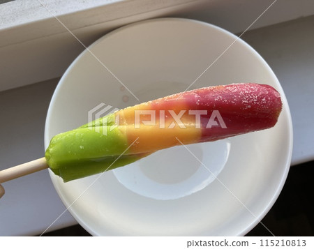 Multicolored sweet ice cream on a stick 115210813