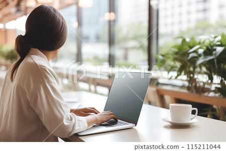Remote work using laptop blank screen woman in cafe or coworking space 115211044