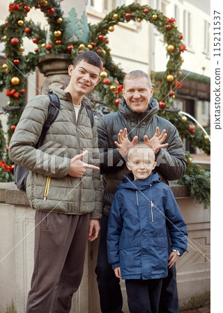 Joyful Family Portrait: Father and Two Sons by Festive Vintage Fountain. Joyful Family Portrait: Father and Two Sons by Festive Vintage Fountain. 115211537