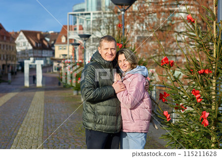 couple in love A guy and a girl hugging on the street of the old European town of Bietigheim-Bissingen in Germany on Christmas Eve. The city streets are decorated with Christmas trees and New Year's couple in love A guy and a girl hugging on the street of the old European town of Bietigheim-Bissingen in Germany on Christmas Eve. The city streets are decorated with Christmas trees and New Year's 115211628