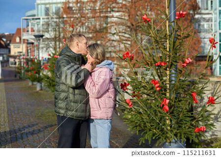 couple in love A guy and a girl hugging on the street of the old European town of Bietigheim-Bissingen in Germany on Christmas Eve. The city streets are decorated with Christmas trees and New Year's couple in love A guy and a girl hugging on the street of the old European town of Bietigheim-Bissingen in Germany on Christmas Eve. The city streets are decorated with Christmas trees and New Year's 115211631
