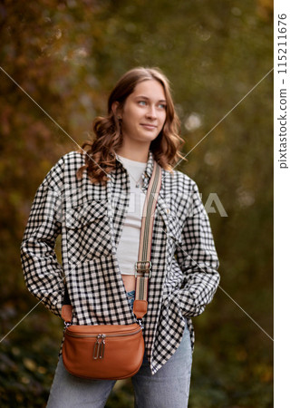 Autumn Elegance: Girl with Warm Tones, Casual Style, and a Park Stroll. Autumn Woman Portrait. Beauty Fashion Model Girl with Autumnal Make up and Hair style. Fall. Creative Autumn Makeup. Beautiful Autumn Elegance: Girl with Warm Tones, Casual Style, and a Park Stroll. Autumn Woman Portrait. Beauty Fashion Model Girl with Autumnal Make up and Hair style. Fall. Creative Autumn Makeup. Beautiful 115211676