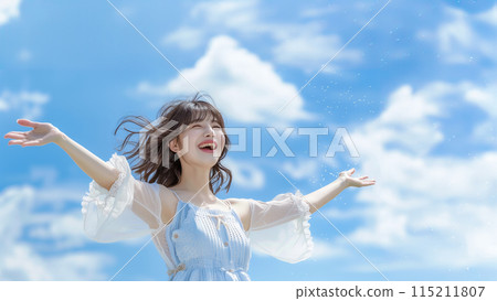 Smiling woman raising her hands up to the sky 115211807