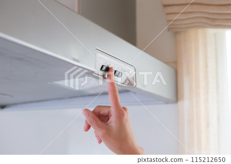 A housewife's hand turning on the ventilation fan 115212650
