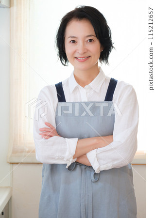 Portrait of a middle-aged woman standing in the kitchen Portrait of a middle-aged woman standing in the kitchen 115212657