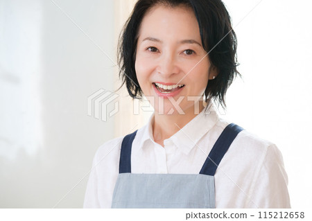 Portrait of a middle-aged woman standing in the kitchen Portrait of a middle-aged woman standing in the kitchen 115212658