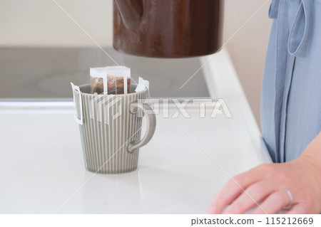 中年婦女的手將熱水倒入滴濾咖啡中 中年婦女的手將熱水倒入滴濾咖啡中 115212669