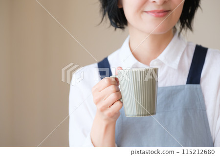 A middle-aged woman spending an afternoon in the living room A middle-aged woman spending an afternoon in the living room 115212680