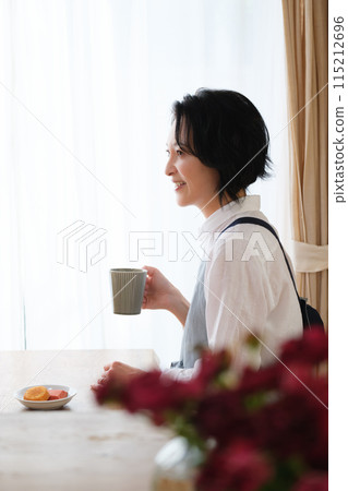 A middle-aged woman spending an afternoon in the living room A middle-aged woman spending an afternoon in the living room 115212696