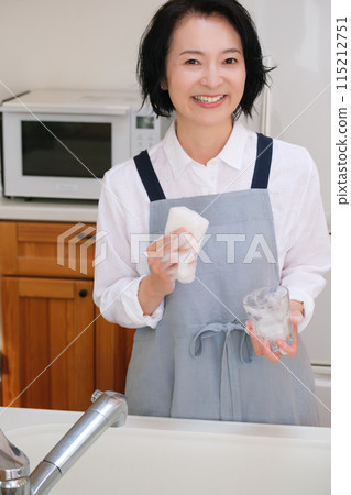 Middle-aged woman washing cups in the kitchen 115212751