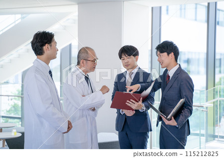 男醫師和醫療資訊代表MR在醫院微笑交談 男醫師和醫療資訊代表MR在醫院微笑交談 115212825