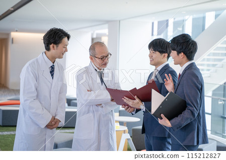 男醫師和醫療資訊代表MR在醫院微笑交談 男醫師和醫療資訊代表MR在醫院微笑交談 115212827