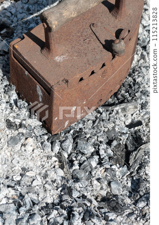 Rare iron working on coals. Against the background of extinct coals. Rare iron working on coals. Against the background of extinct coals. 115213828