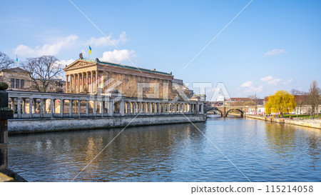 A serene view of the Old National Gallery located along the riverbank in Berlin, with classical architecture and clear skies. Germany 115214058