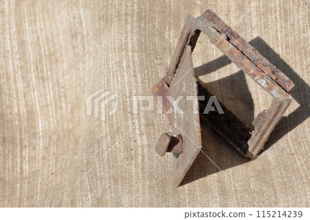 Old cast iron door for the stove. It stands on a coarse cloth. 115214239