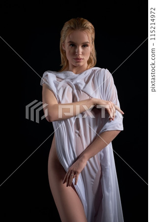 Confident nude woman covered with wet cloth in dark studio Confident nude woman covered with wet cloth in dark studio 115214972