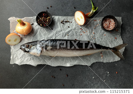 Dried mackerel herring on a black cutting board on a black background Dried mackerel herring on a black cutting board on a black background 115215371